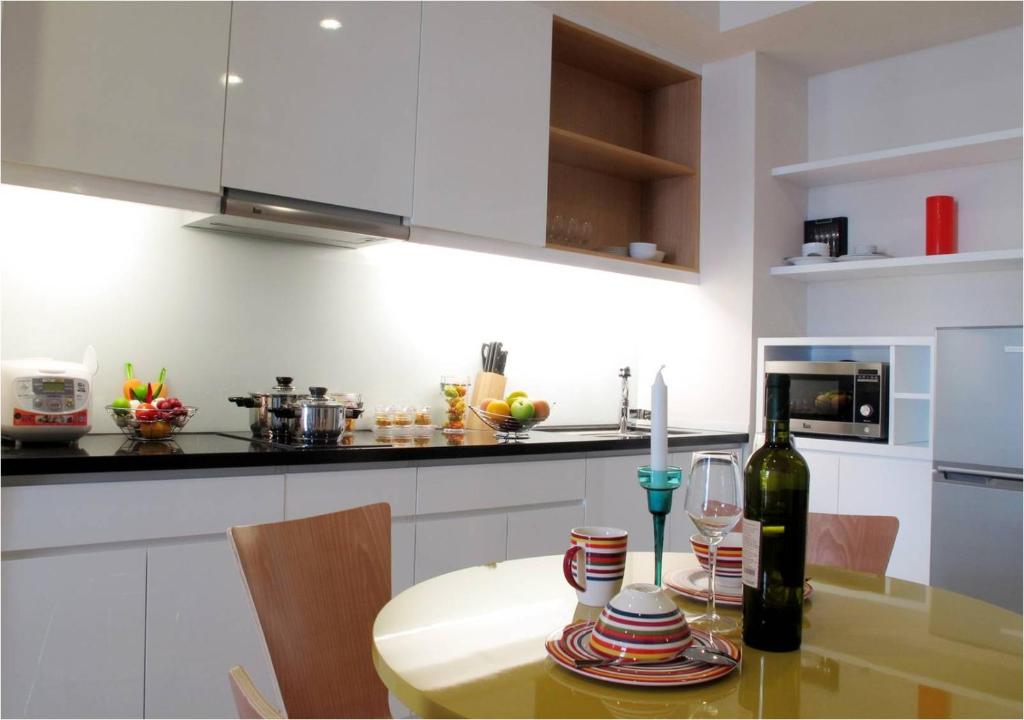 a kitchen with a table with a bottle of wine at Bluesky Serviced Apartment Airport Plaza in Ho Chi Minh City