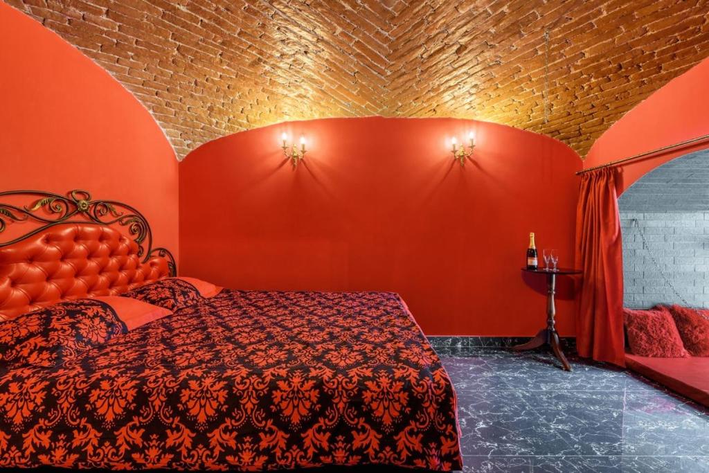 ein rotes Schlafzimmer mit einem Bett und einer roten Wand in der Unterkunft Apartment Masoch Style in Lwiw