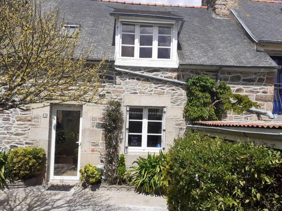 a stone house with a white door and windows at Chez Édouard et Aline in Ploubazlanec