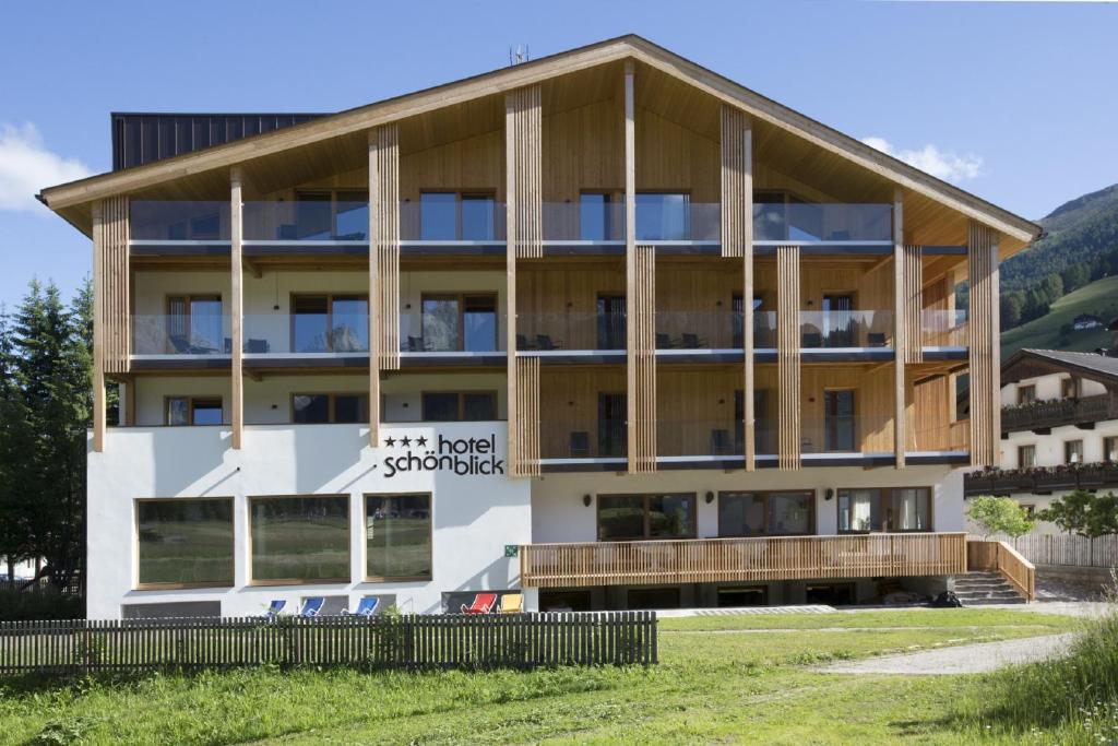 a large white building with a wooden roof at Hotel Schoenblick in Sesto