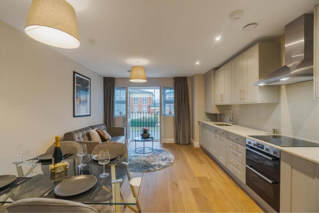 a kitchen and living room with a couch and a table at Modern 2 Bed Apartment - Allocated Parking in Windsor