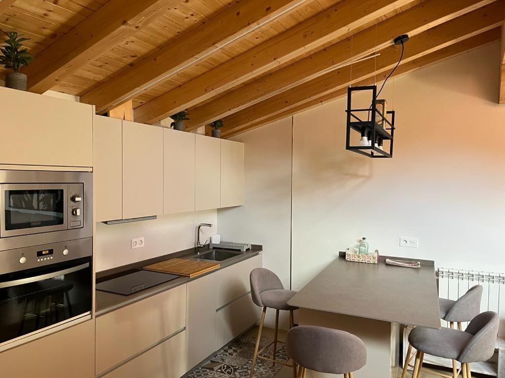 a kitchen with a table and chairs and a stove at Suite a las orillas del Duero 