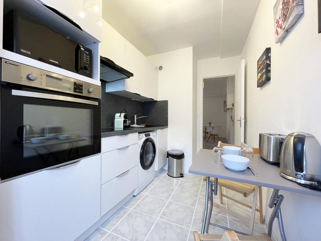 a kitchen with a washer and dryer at L&#39;Escapade in Chartres