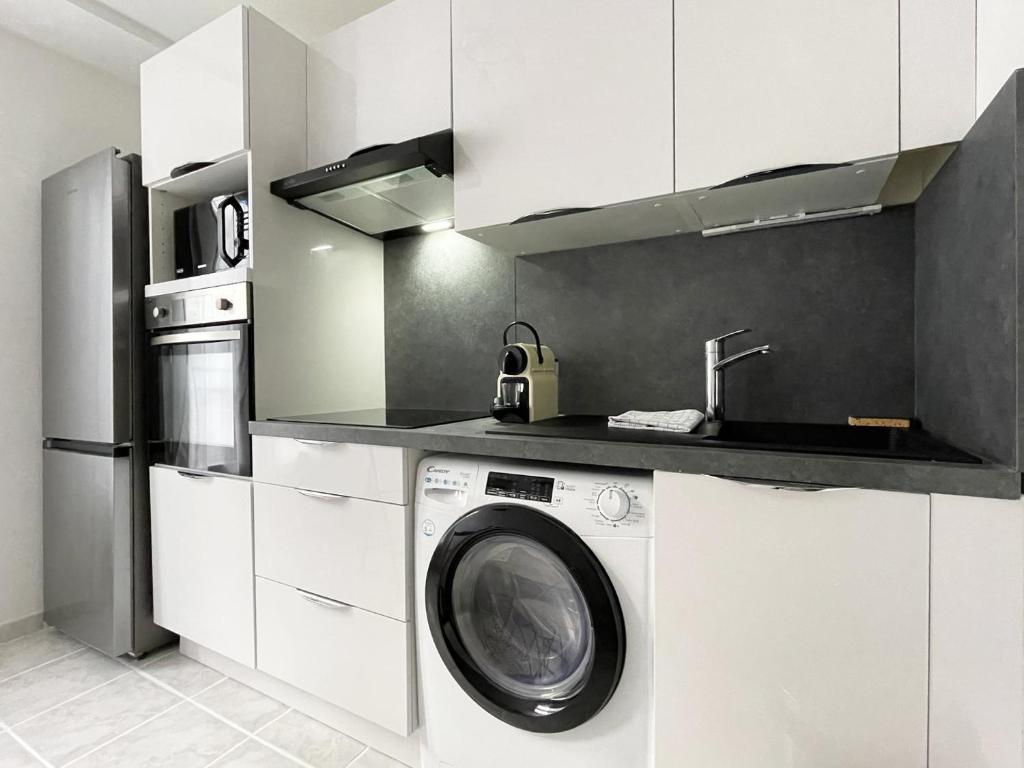 a kitchen with a washing machine and a sink at L&#39;Escapade in Chartres