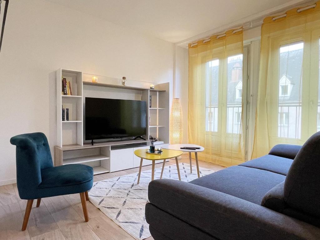 a living room with a couch and a tv at L&#39;Escapade in Chartres