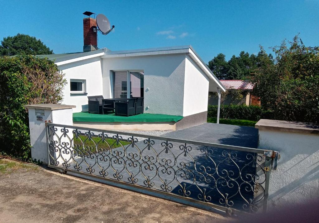 a white house with a fence in front of it at Bungalow Lange in Schwielochsee