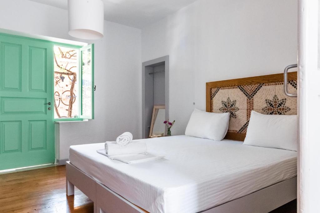 a bedroom with a bed with a green door at Himara Hostel in Himare