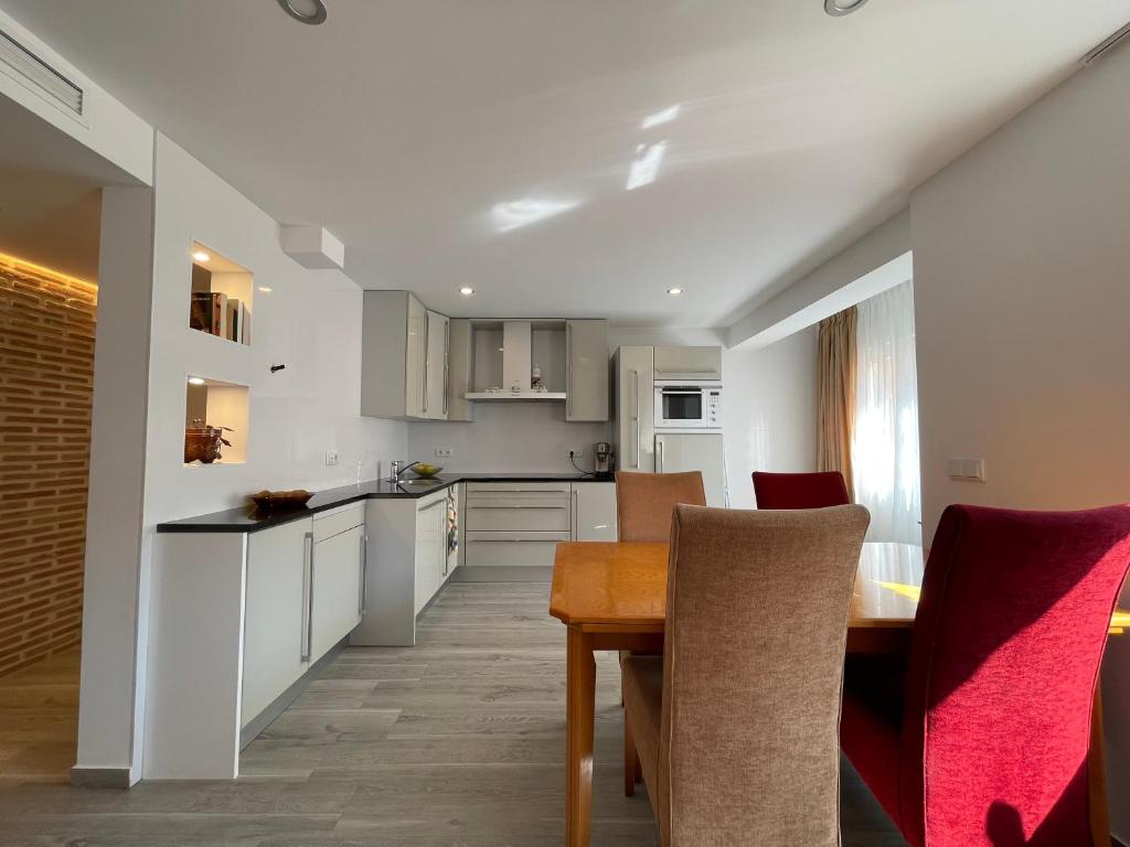 a kitchen with white cabinets and a wooden table at Igidelux 2 in Villajoyosa
