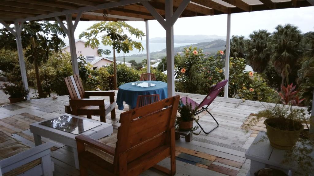 patio con sedie, tavolo e vista di Villa Zéphyr Domaine roses des vents a Sainte-Marie