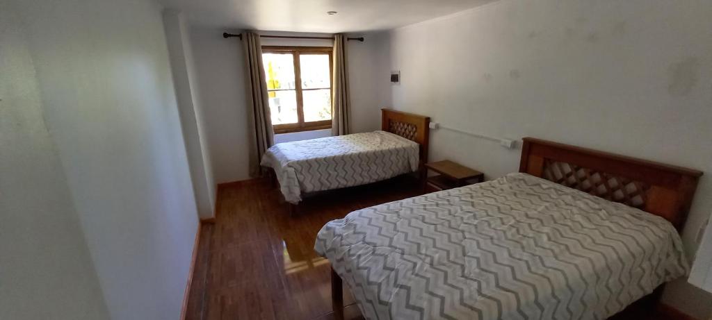 a room with two beds and a window at Hospedaje Los vasquez in Linares