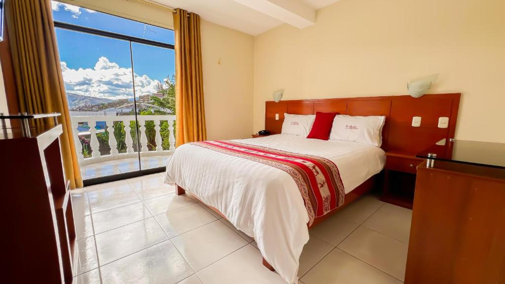 a bedroom with a bed and a large window at La Mansion Casa Hotel in Andahuaylas