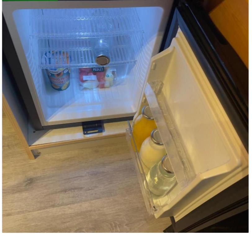 an open refrigerator filled with lots of food and drinks at Heatherbrae Cosy Wooden Pod in Kyle of Lochalsh