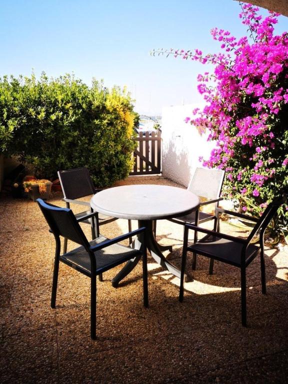 d'une table, de deux chaises, d'une table et de quelques fleurs dans l'établissement Résidence Palmyra - Appartement 2 pièces avec wifi au rez-de-chaussée à LE BARCARES - CAP COUDALERE MAE-4404, au Barcarès