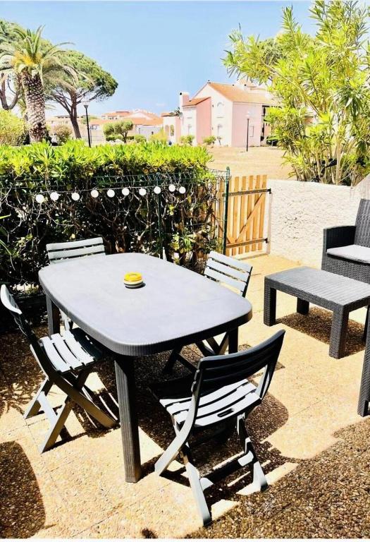 - une table de pique-nique et des chaises assises sur une terrasse dans l'établissement Résidence Antigua - T2 4 couchages LE BARCARES - CLIMATISATION en option MAE-7984, au Barcarès
