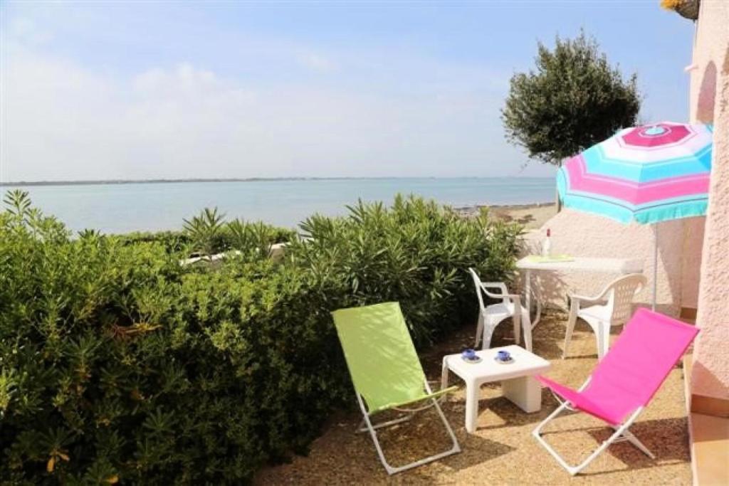 - une terrasse avec des chaises et un parasol sur la plage dans l'établissement Résidence Grenada - Appartement 4 pièces au rez-de-chaussée à LE BARCARES - CAP COUDALERE MAE-6954, au Barcarès