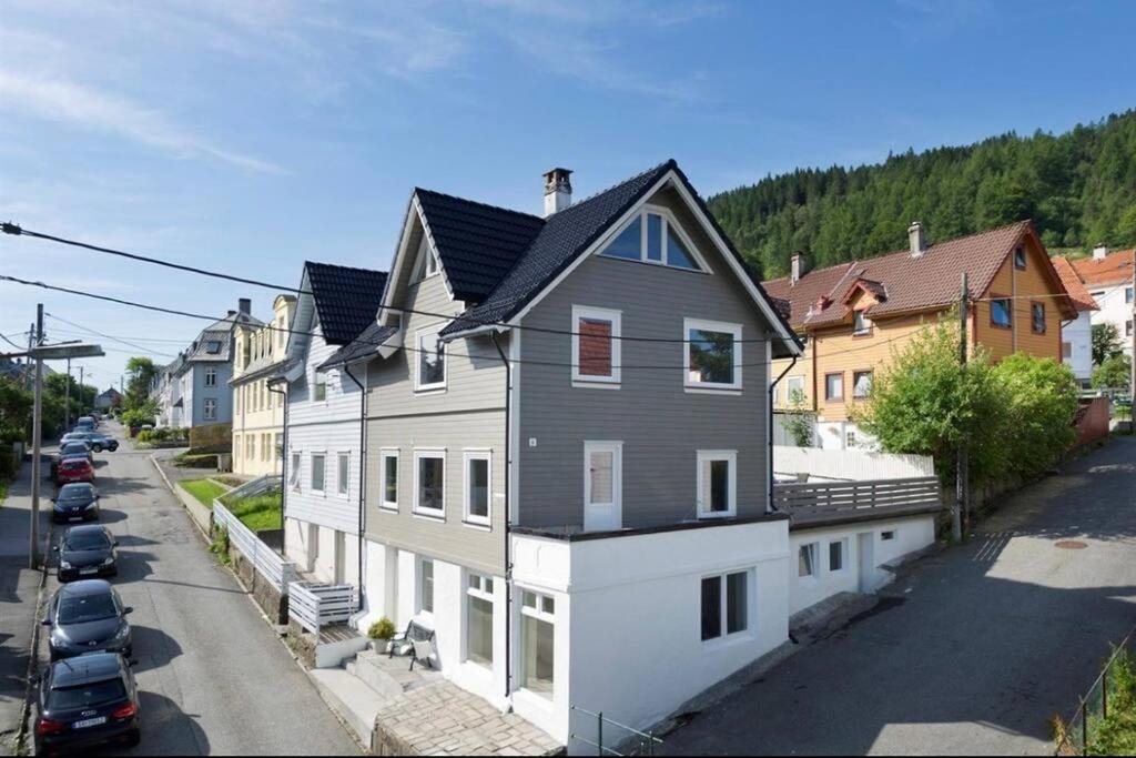 a large white and gray house on the side of a street at Spacious and Beautiful Apartment in Bergen with free parking in Bergen