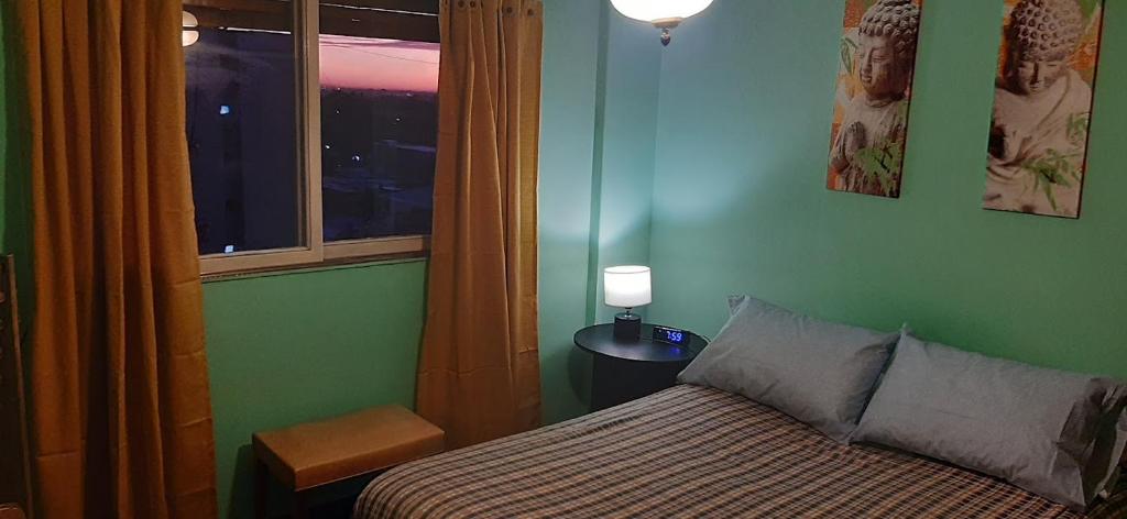 a small bedroom with a bed and a window at Habitaciónes en Departamento Céntrico in Mendoza