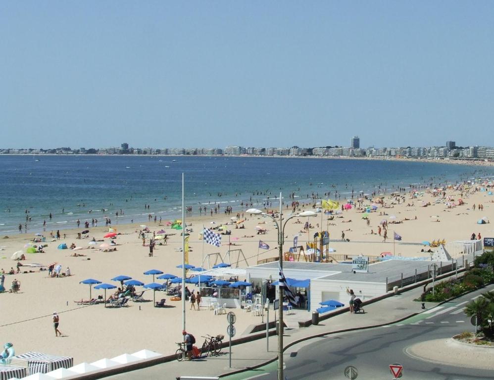 un grand groupe de personnes sur une plage dans l'établissement Studio Face Mer 3 Personnes, à Pornichet