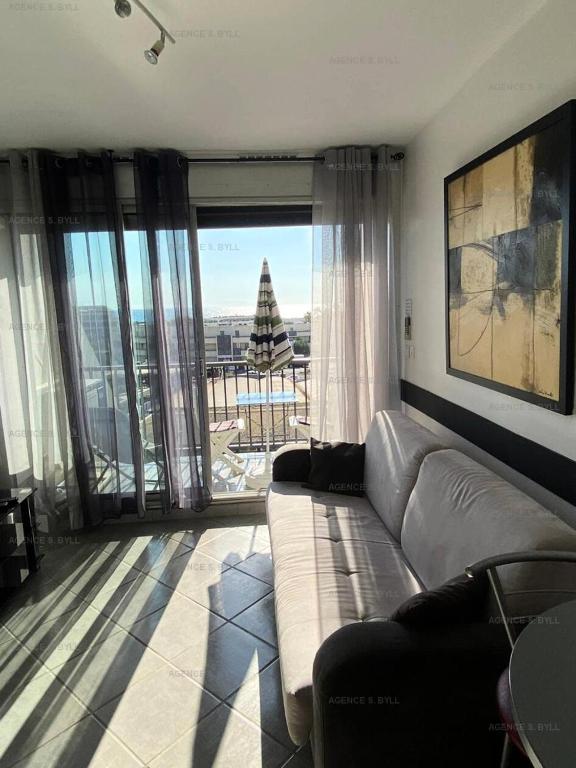 - un salon avec un canapé et un arbre de Noël dans l'établissement Résidence Héliopolis Bâtiment Fgh - Studio 2 couchages CAP d'AGDE MAE-4574, au Cap d'Agde