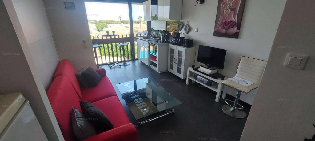 salon z czerwoną kanapą i telewizorem w obiekcie Résidence Port Venus - Studio 2 pers. - Port Vénus MAE-4334 w Cap d'Agde