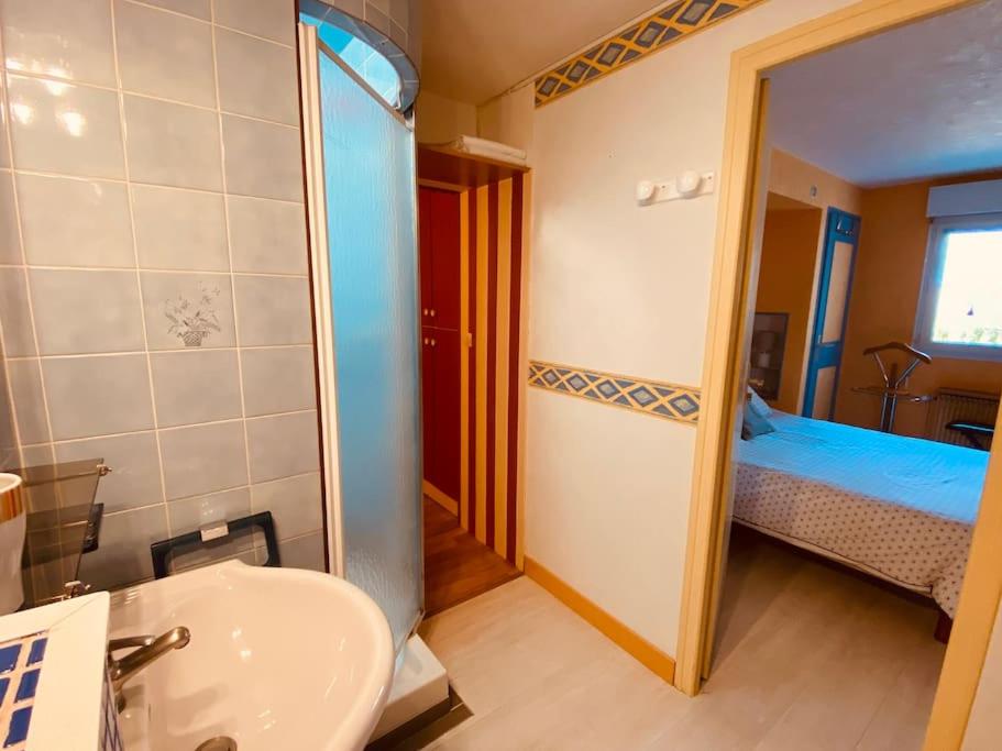 a bathroom with a sink and a bedroom with a bed at Gite pour pros entre Niort et Fontenay &#47; Tout compris in Benet