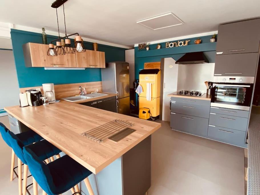 a kitchen with a wooden counter top and blue walls at Gite pour pros entre Niort et Fontenay &#47; Tout compris in Benet