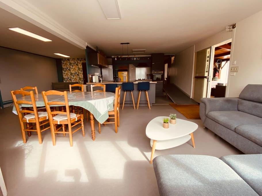 a living room with a table and chairs and a couch at Gite pour pros entre Niort et Fontenay &#47; Tout compris in Benet