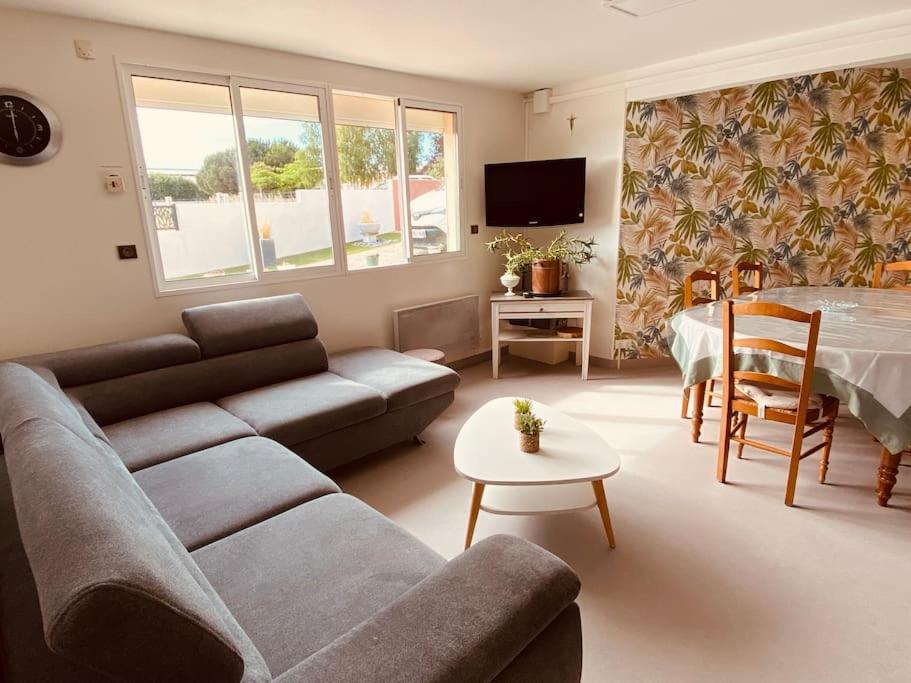 a living room with a couch and a table at Gite pour pros entre Niort et Fontenay &#47; Tout compris in Benet