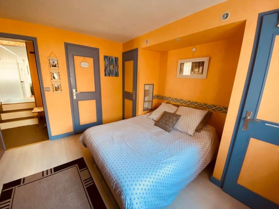 a bedroom with a bed in a room with orange walls at Gite pour pros entre Niort et Fontenay &#47; Tout compris in Benet