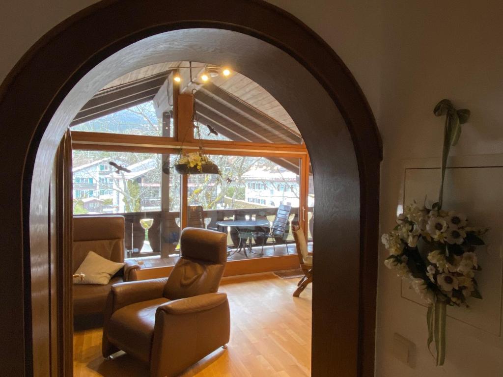 einen Torbogen in einem Wohnzimmer mit einem Sofa und einem Stuhl in der Unterkunft Ferienwohnung Partenkirchen in Garmisch-Partenkirchen