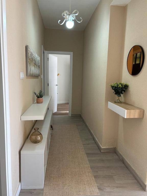 un pasillo con estanterías blancas y un pasillo con puerta en Acogedor Bajo en Meira, en Moaña