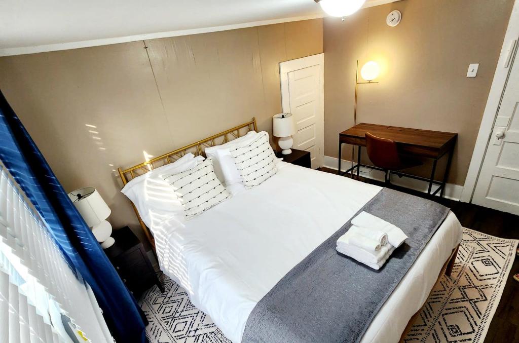1 dormitorio con 1 cama blanca grande y escritorio en Magnolia House, en Lafayette
