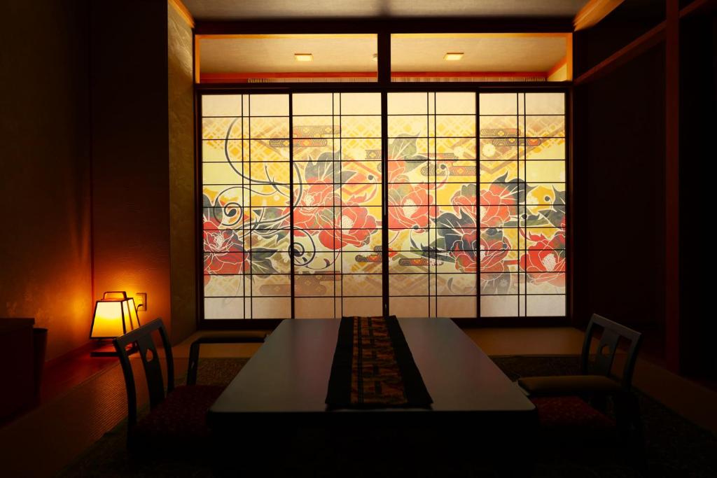 mesa de comedor con vidriera en 別所温泉 七草の湯, en Ueda