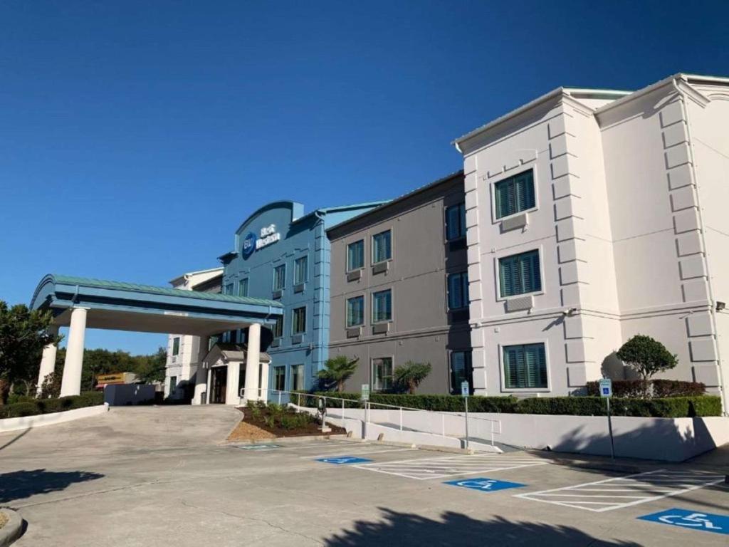 um grande edifício branco com estacionamento em Best Western Houston Bush IAH Intercontinental Airport Inn em Humble