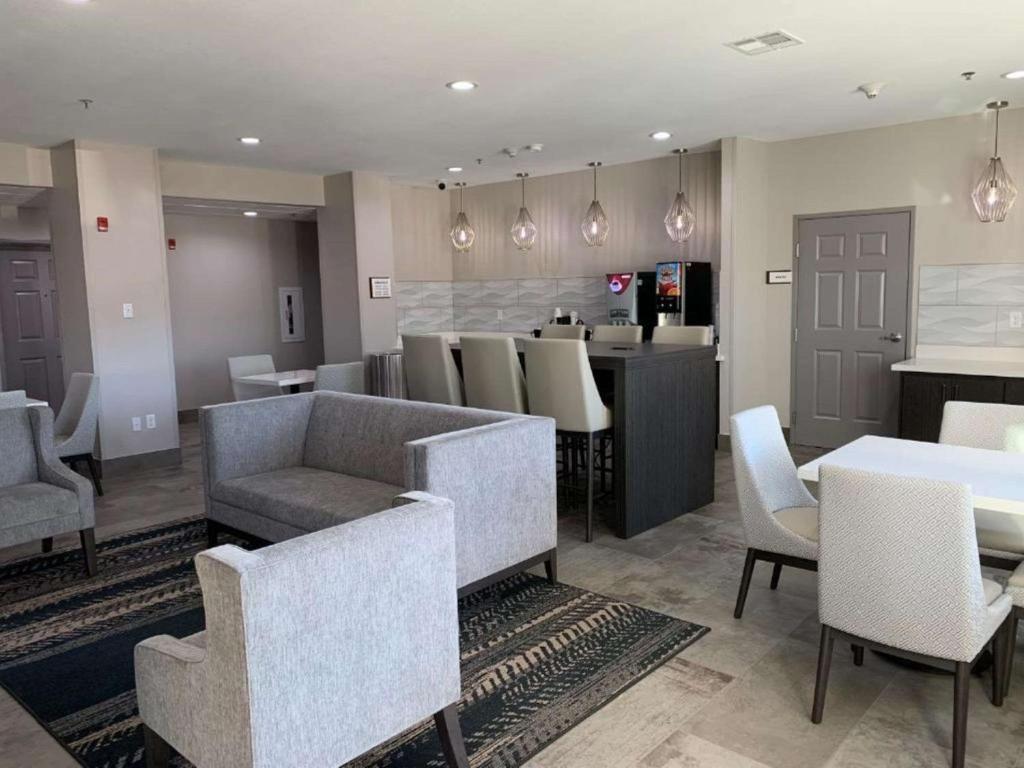 a restaurant with tables and chairs and a bar at Best Western Houston Bush IAH Intercontinental Airport Inn in Humble