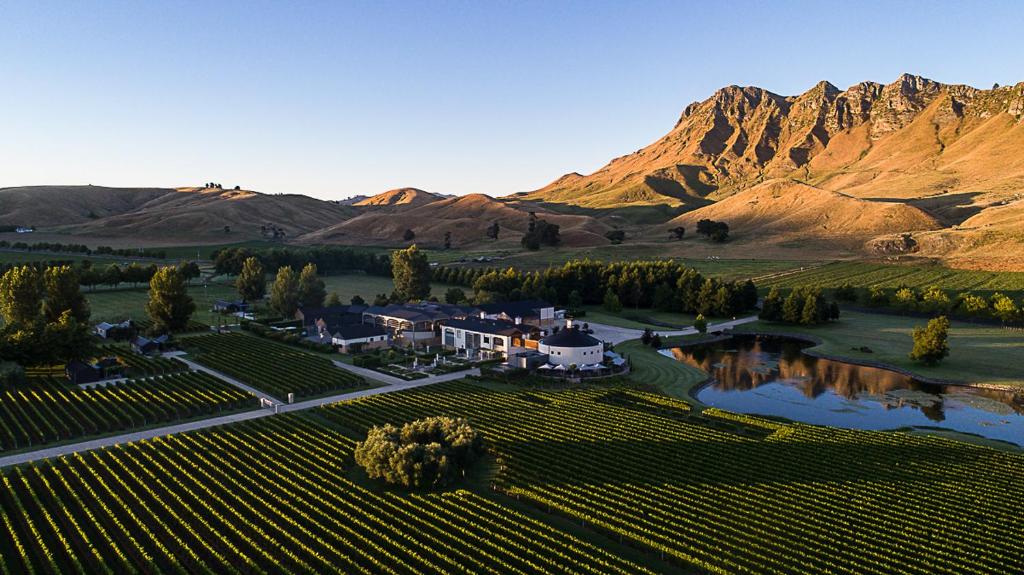 an aerial view of a house in a vineyard with mountains at Craggy Range Luxury Vineyard Retreat in Havelock North
