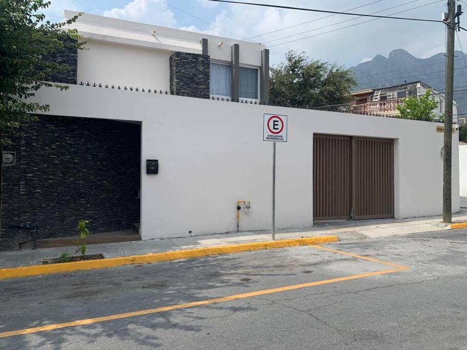 a white building with a garage with a no parking sign at CASA COMPLETA CON PATIO, ASADOR Y ESTACIONAMIENTO in Monterrey