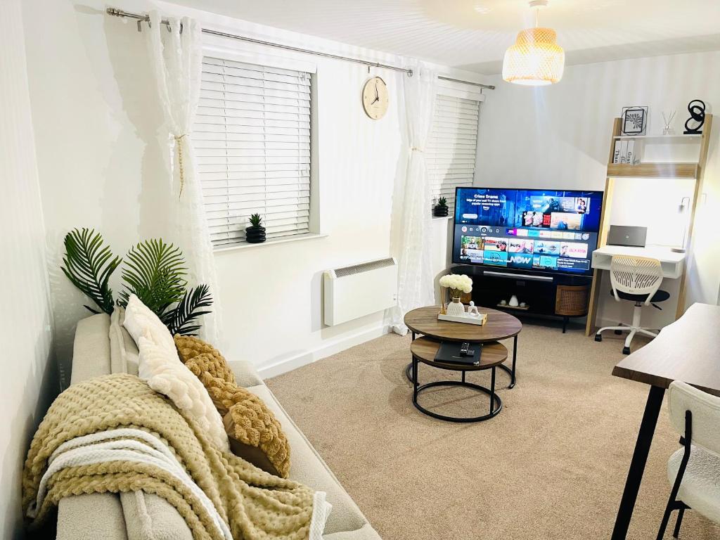 uma sala de estar com um sofá e uma televisão em Cozy Apartment in Birchwood em Risley