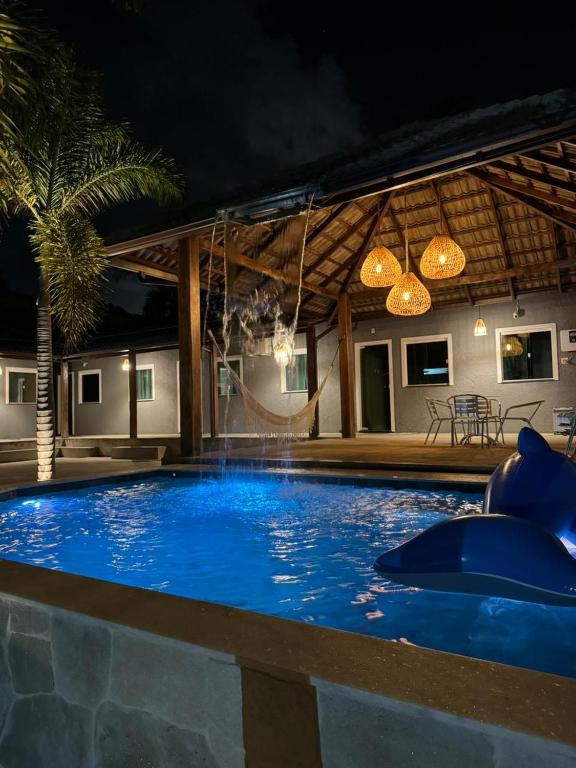 une grande piscine bleue avec toboggan dans une maison dans l'établissement Flat do Atlântico, à Salinópolis