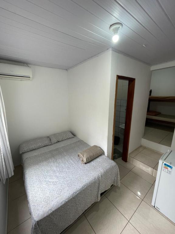 um quarto com uma cama num quarto branco em Pousada 1111 em Balneário Camboriú