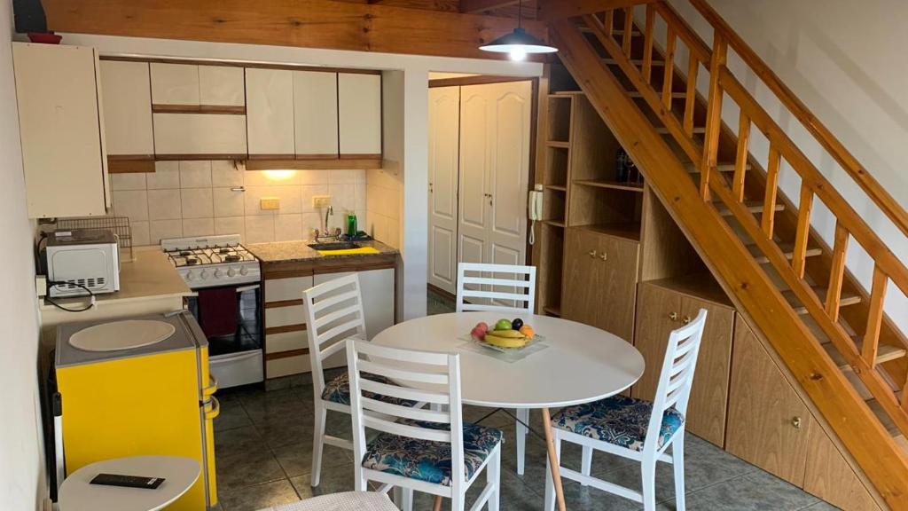 a kitchen with a table and chairs and a staircase at Amaneceres frente al Mar Dpto 2 in Puerto Madryn