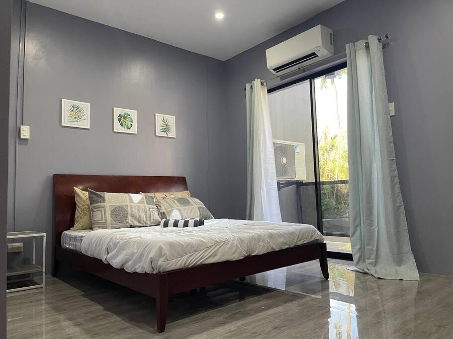 a bedroom with a bed and a window at Cozy 2 storey fully furnished house. in Davao City
