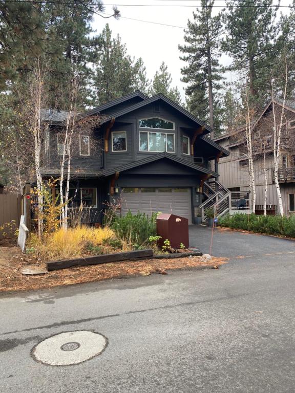 a black house with a garage on the side of the road at Lake Tahoe Luxury Guest Quarters in South Lake Tahoe