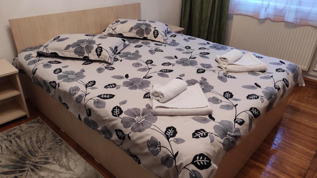 ein Bett mit einer blauen und weißen Bettdecke und Kissen in der Unterkunft Apartament Central in Lupeni
