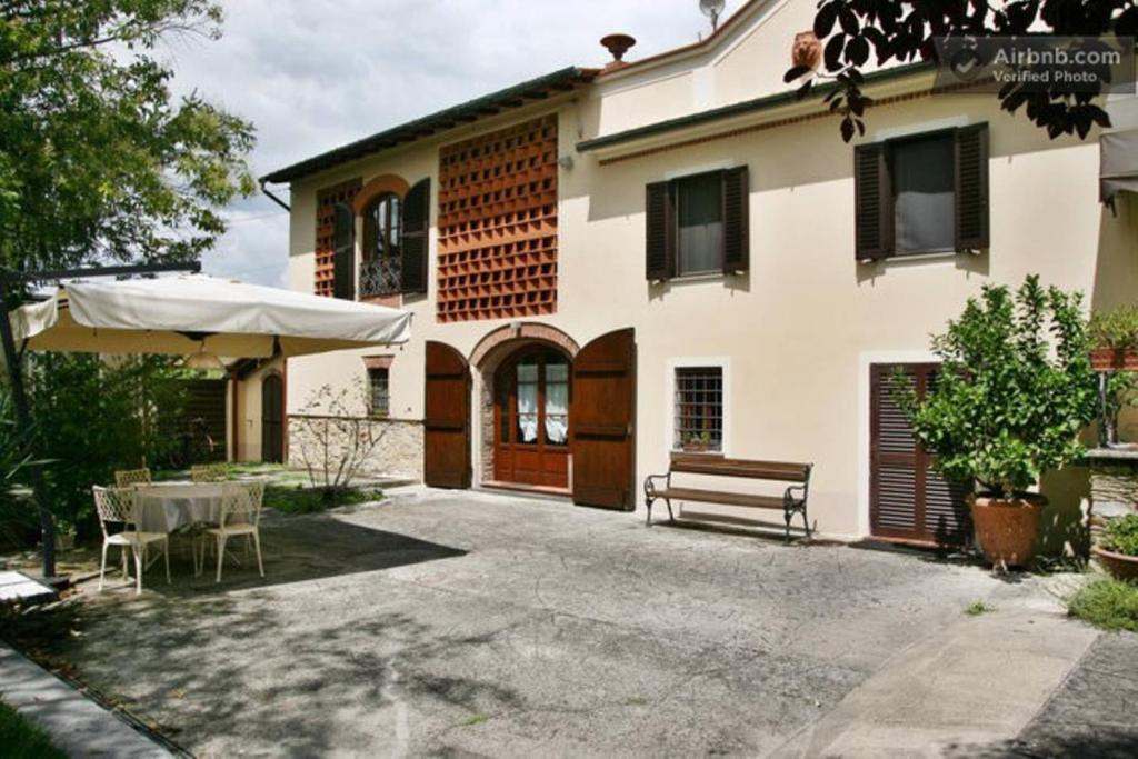 una casa con una panchina davanti di Villa Camilla - TINY - EXCLUSIVE POOL a Lucca