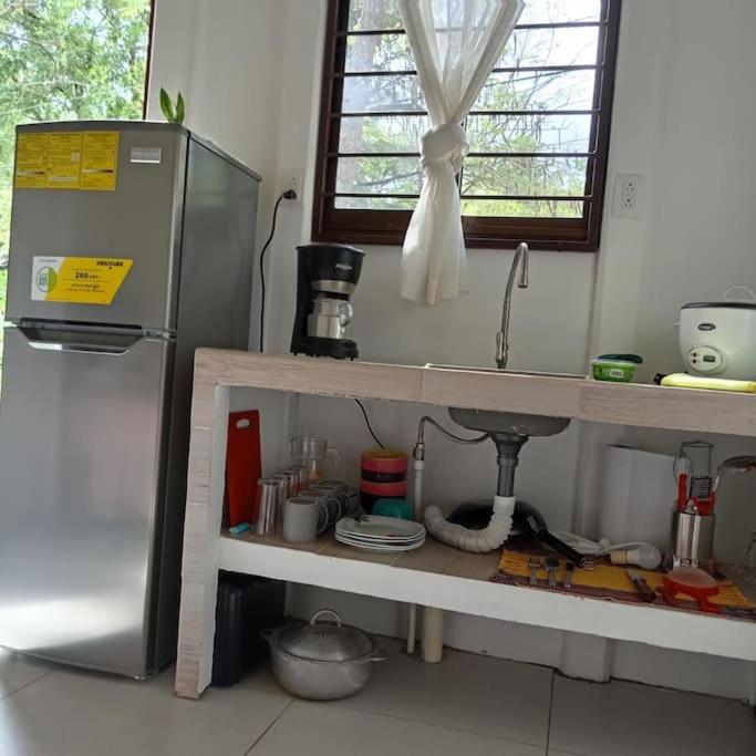 a kitchen with a sink and a refrigerator at Camping Mena’s in La Cruz