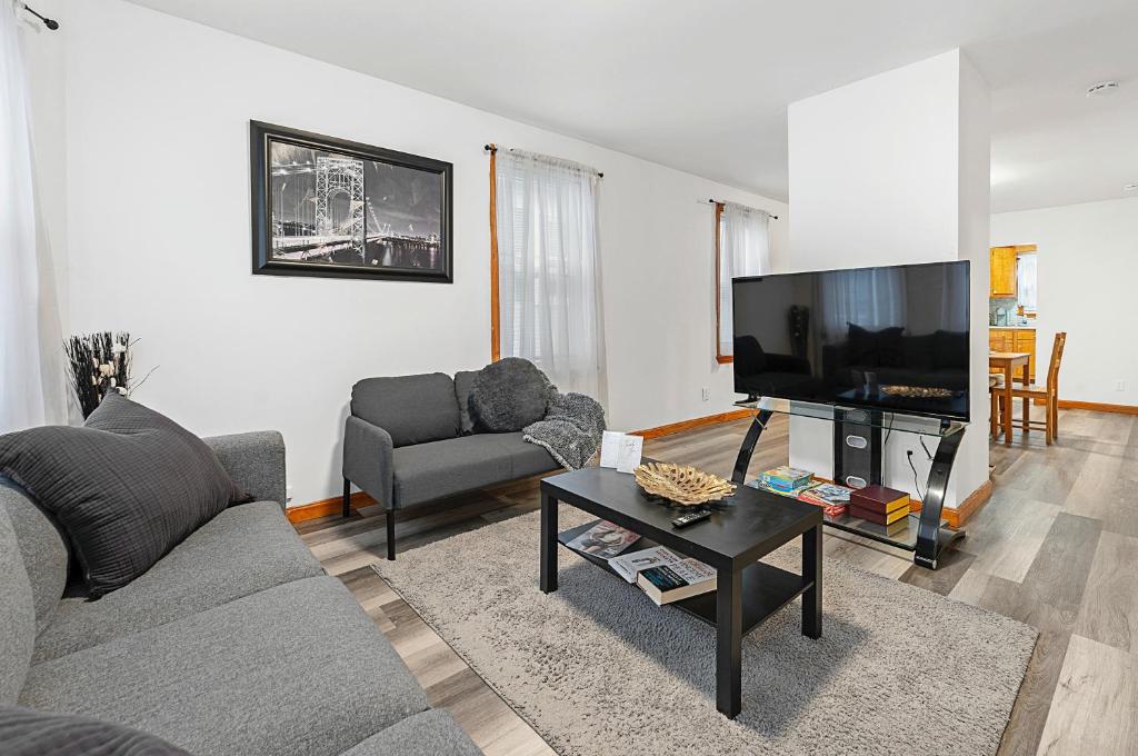 uma sala de estar com um sofá e uma televisão de ecrã plano em Vida Comfy Inn 2br Apartment KING BED 8 mins to downtown and ferry em New Bedford
