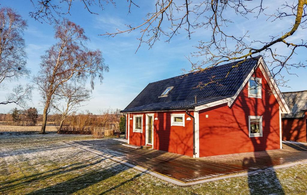 a red barn with a black roof in a field at Nice Home In Falkenberg With Wi-fi in Falkenberg