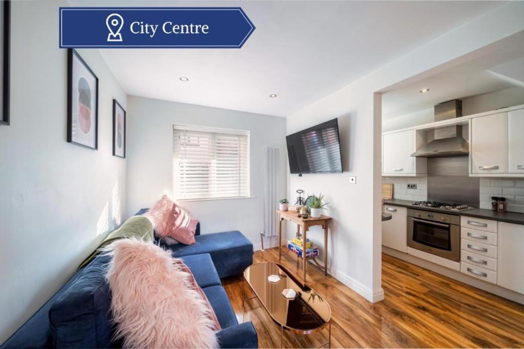 a living room with a blue couch and a kitchen at Charming & Central House with Garden and Free Parking in Beverley