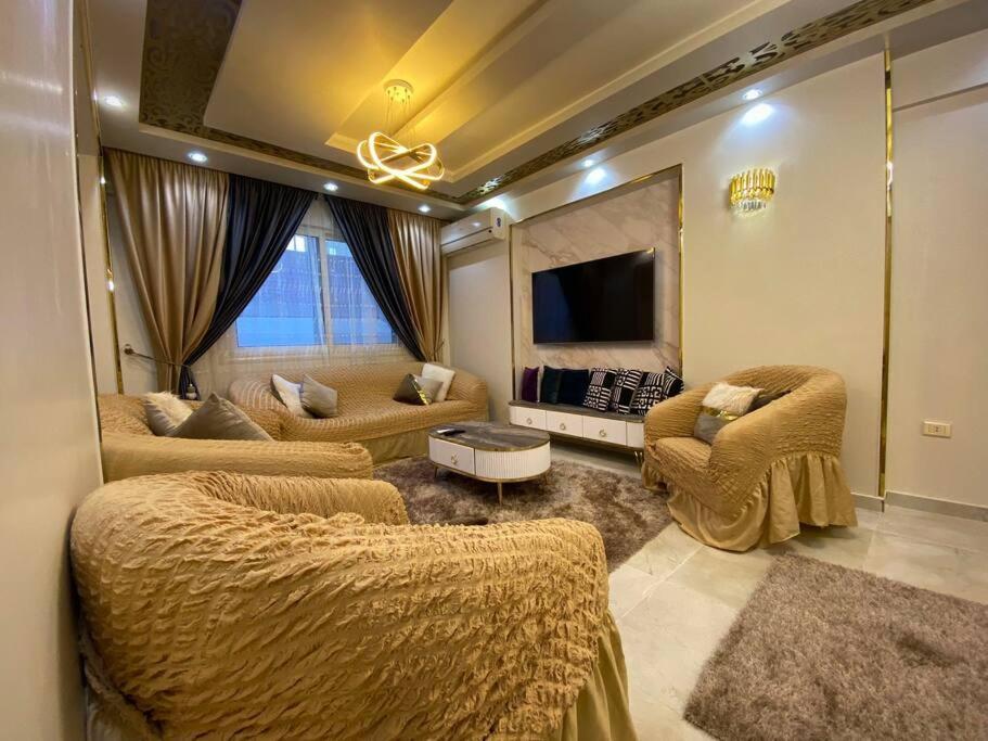 ein großes Wohnzimmer mit Sofas und einem TV in der Unterkunft القمة للشقق المخدومة in Kairo